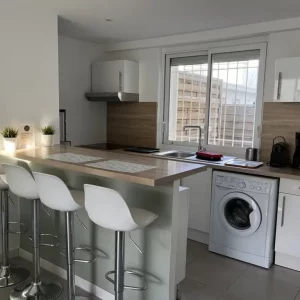 "Cuisine équipée avec réfrigérateur, micro-ondes et ustensiles, ouverte sur le salon du gite "bateau" en Camargue pour de superbes vacances