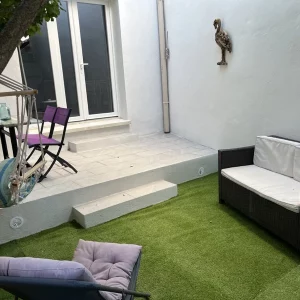 ambiance chaleuresue dans cet exterieur du gite "les chevaux" avec salon de jardin et hamac