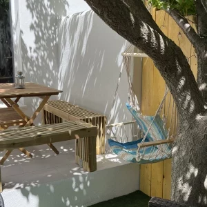 Vue extérieure du gîte avec hamac et salon de jardin ombragé aux Saintes-Maries-de-la-Mer